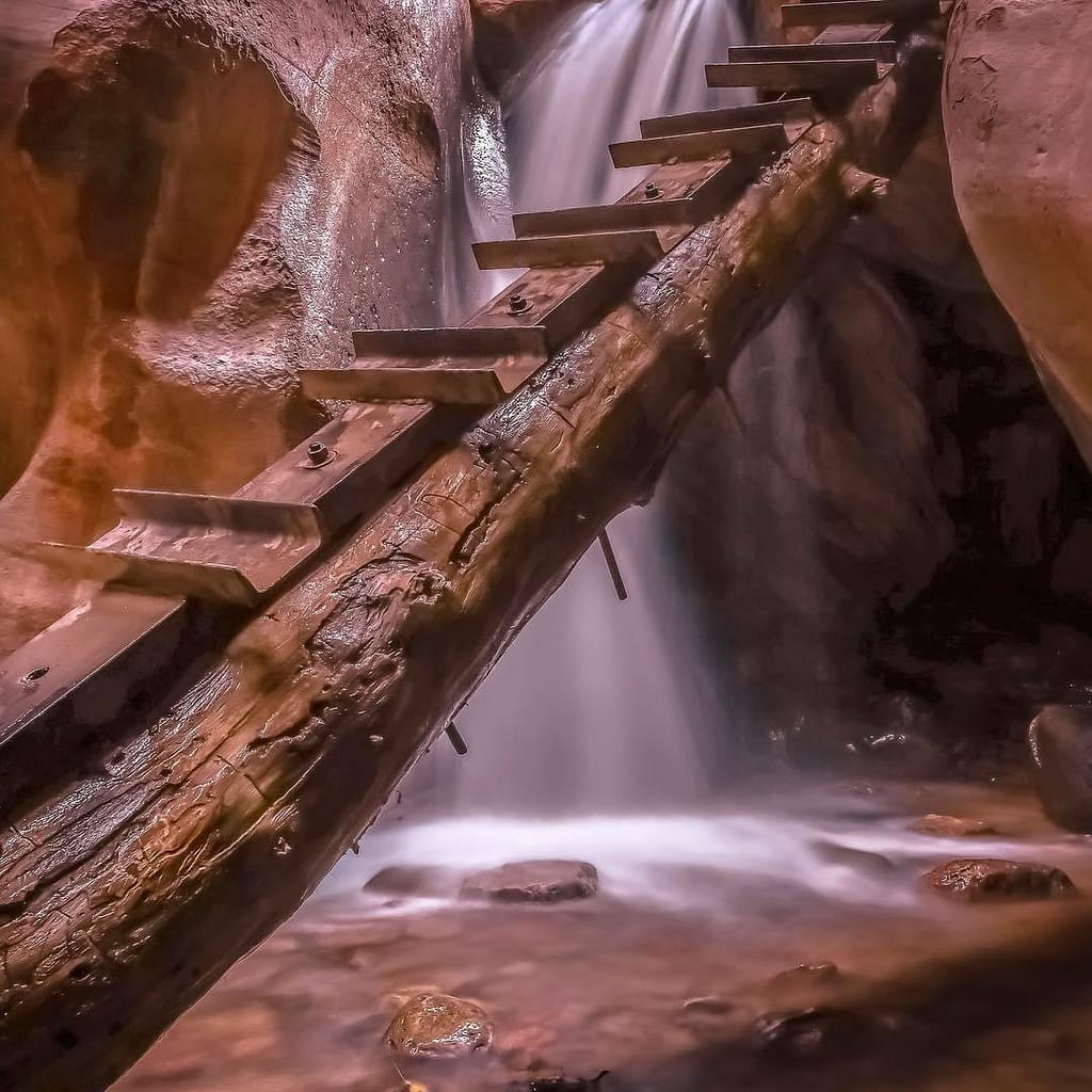 A climbing ladder leads from the ground to the top of a waterfall in a slot canyon in Kanarraville, Utah.
